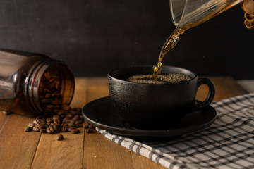 Pouring coffee on a black cup