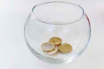 Coins into glass ball savings crisis economy investment concept  