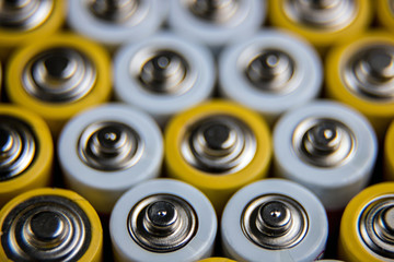 The batteries stand close together and form a beautiful background. Selective focus. Artistic blurring at the edges. Energy source. Patterns.