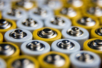 A large number of old AA batteries. The batteries are laid out in a square shape. Batteries form a...