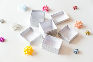 Fototapeta na wymiar Open empty light gift boxes and colorful bows on white background. Festive holidays concept. 