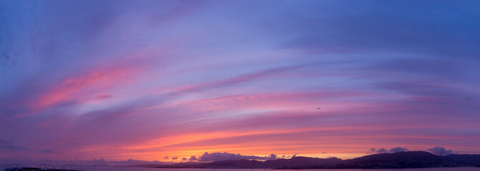 Naklejka na ściany i meble Panoramic sky of a sunset full of clouds