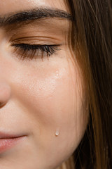Close-up portrait of a crying girl with spreading make-up. Stress due to work and problems in life.