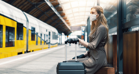 Fototapeta na wymiar Woman wearing white protective face mask is using public transportation during the epidemic outbreak