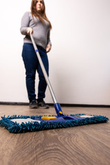 a young girl mops the floor in an apartment. general cleaning of the house. employee of a cleaning company at work.