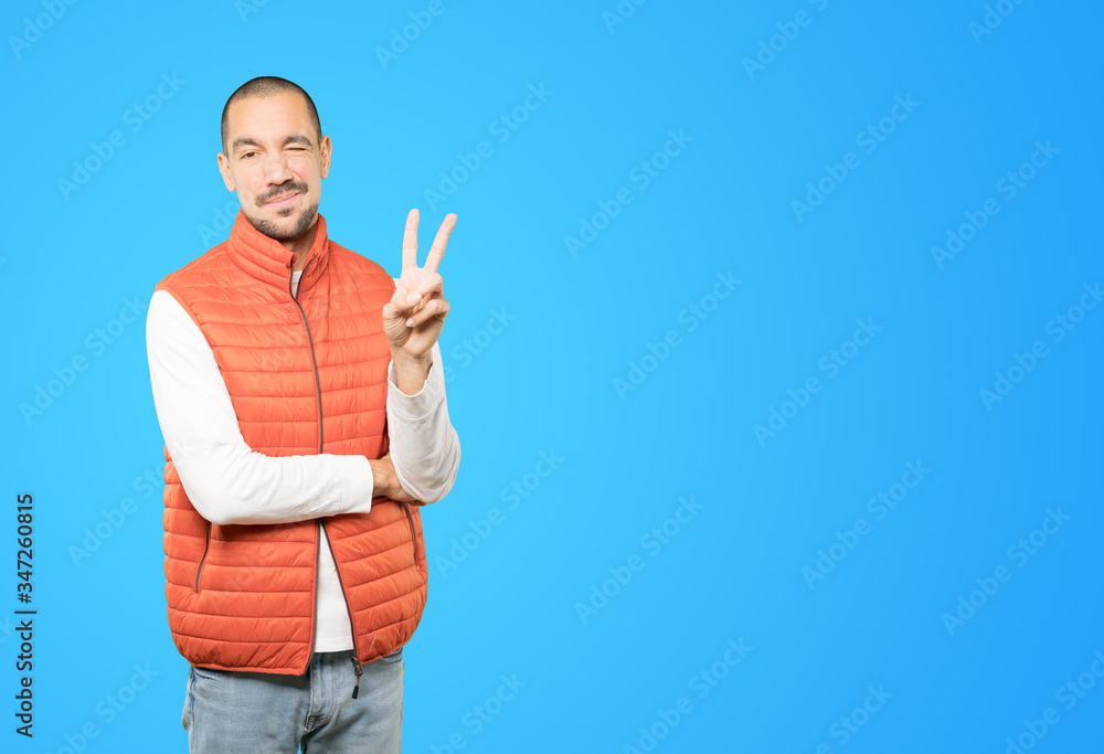 Wall mural young man making a number two gesture