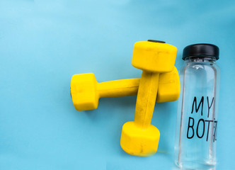 Sport. Top image with dumbbells and glass bottle of water on a blue background, ready to be added...