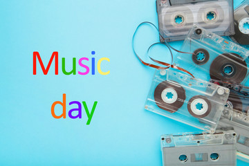Inscription music day with old colorful cassettes on a blue background. Music day