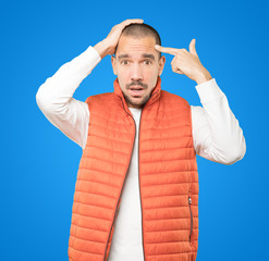 Depressed young man making a suicide gesture