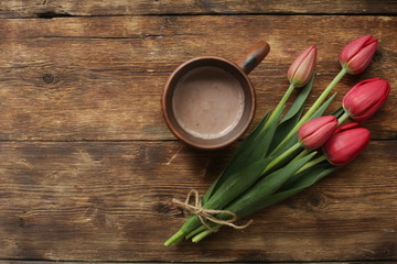 tulips on a wooden table with a cup of cocoa
