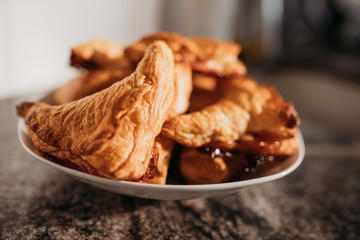 home made puff pastry buns. Triangular in shape with caramelized sugar. On a white plate. Close