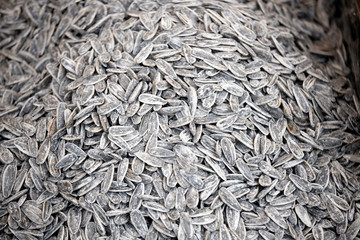 Sunflower seeds in black and white. Photographed on the counter in front of the salted and roasted market. Close up.