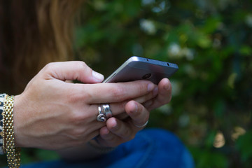 girl with mobile consulting and writing with him. hands and mobile close up