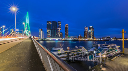 Fototapeta na wymiar Long exposure shot at the Erasmus bridge in Rotterdam, the Nederlands, during the blue hour with a view over the beautiful skyscrapers.