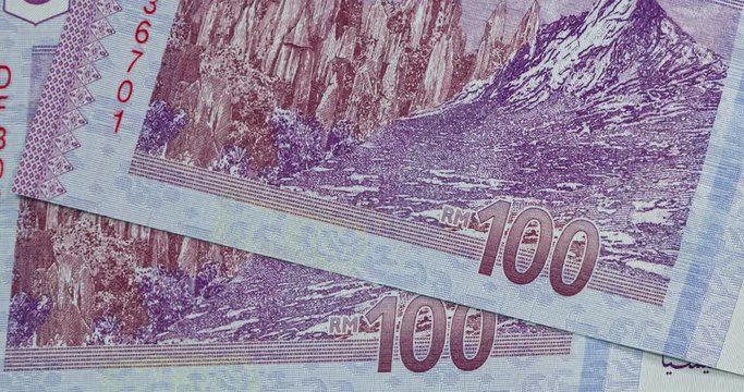 Detailed macro capture of brand new RM 100 with sequential number. Macro shot from the back of Malaysian money with the picture of Mount Kinabalu. Close up footage, panning over RM100