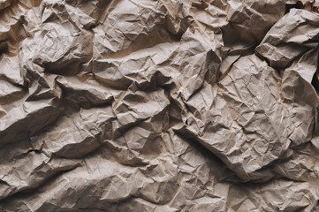 Background from heavily crumpled vintage paper, which is used as a wrapper. The texture of cardboard made from recycled materials.