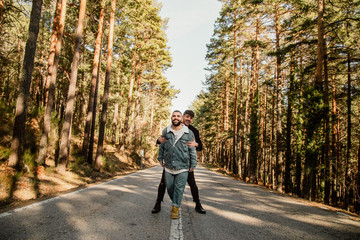 Happy gay couple in love on a mountain road