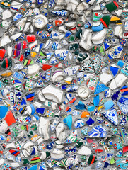 Close up of a wall, decorated with broken pieces of handmade ceramic pots.