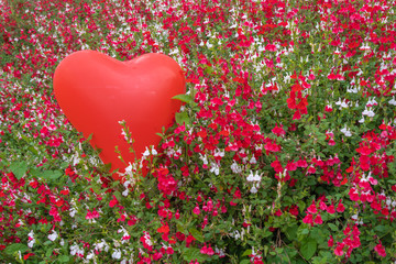 Gennevilliers, France - 05 08 2020: Heart shaped red balloon surrounded by red and white flowers...