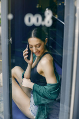 Beautiful girl in a cafe. Stylish girl in a green blouse. Lady near the window