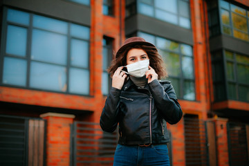 young woman  in the city in mask. coronavirus. covid-19. 