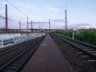 Fototapeta premium czech railway tracks at sunset and in the background is prague architecture in spring 2020