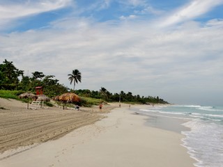 Fotografía del la Playa de Varadero, Cuba con las aguas azules del Mar Caribe y la arena blanca bajo un cielo azul con nubes blancas