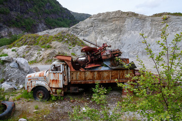 Truck wreck filled with tractor wreck in the midle of nature