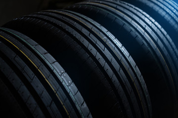 New tires set on the dark background with cold light in the corner. © Dmytro