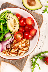 Healthy food. Greek salad with grilled Halloumi cheese, tomatoes, avocado, and arugula. Food recipe background. Close up.cuisine of Cyprus