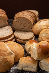 Assortment of baked bread on wooden table background