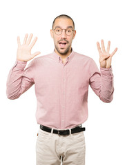 Fototapeta premium Happy young man doing a number nine gesture with his hands