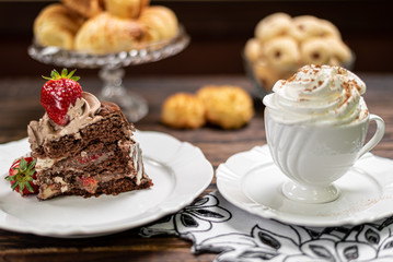 Coffee cup and chocolate cake on wooden table background