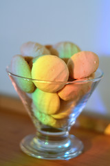 Sequilhos em uma taça de vidro iluminados por um arco-íris
