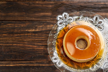 Milk Pudding or Pudim de leite. Brazilian dessert homemade caramel custard pudding. Traditional brazilian flan on wooden background