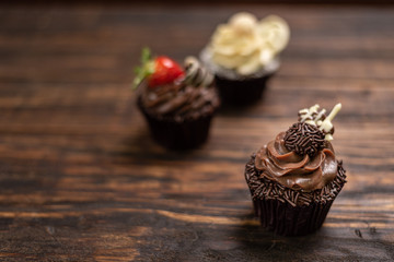Assortment of desserts. Tasty cupcakes on wooden table background