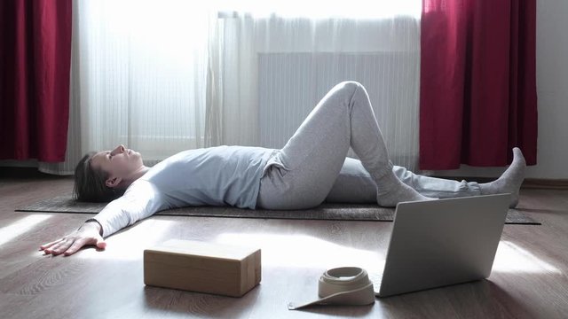 Beautiful woman doing stretching twisitng exercise on the floor