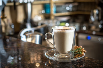 White latte coffee drink with a cookie in a bar