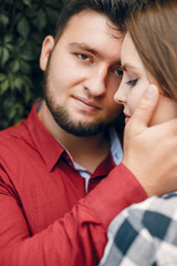 Cute couple in a park. Lady in a chirt. Guy in a red shirt