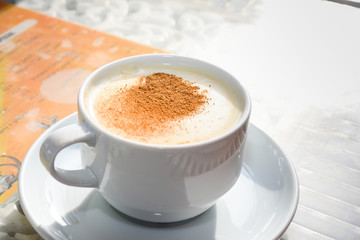 white cup of salep milky hot drink of Turkey with cinnamon powder and sticks healthy spice