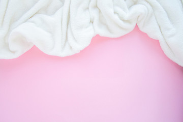 Top view white fluffy plaid on a pink background with copy spase. Cozy staing home concept flat lay composition