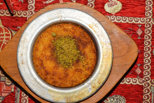 Turkish dessert kunefe with pistachio powder. Kunafa, kadayif with pistachio powder and cheese hot