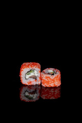 Philadelphia roll with salmon, cheese and cucumber on a black background with reflection. Sushi Philadelphia