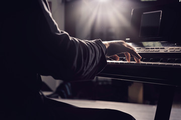 Hands playing a piano keyboard