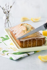 A close up view of a lemon poppy seed loaf being cut into.
