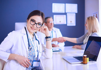 Doctor and patient discussing something while sitting at the table . Medicine and health care concept