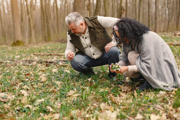 Seniors in a forest. People walks. Family with spring's flowers.