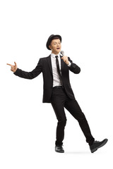 Young guy in a suit and hat dancing and singing on a microphone