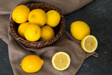 Fresh lemons in the wicker basket on the ground.
