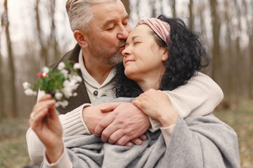 Fototapeta premium Seniors in a forest. People walks. Family with spring's flowers.